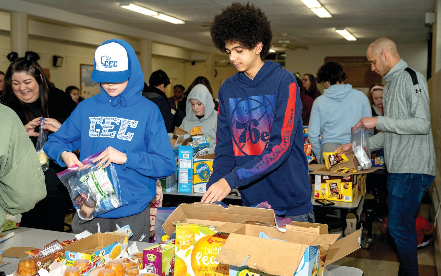 Young people take part in Monday morning’s service project at Our Lady of Grace Catholic School, putting together snack bags that’ll be donated to kids staying with their families at the Bucks County Emergency Homeless Shelter in Levittown.