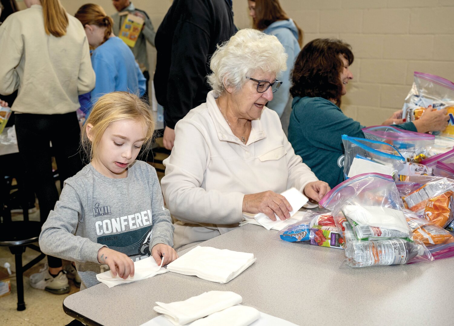 Kayla Berner, left, folds napkins with her grandmother, Theresa Rittenour.