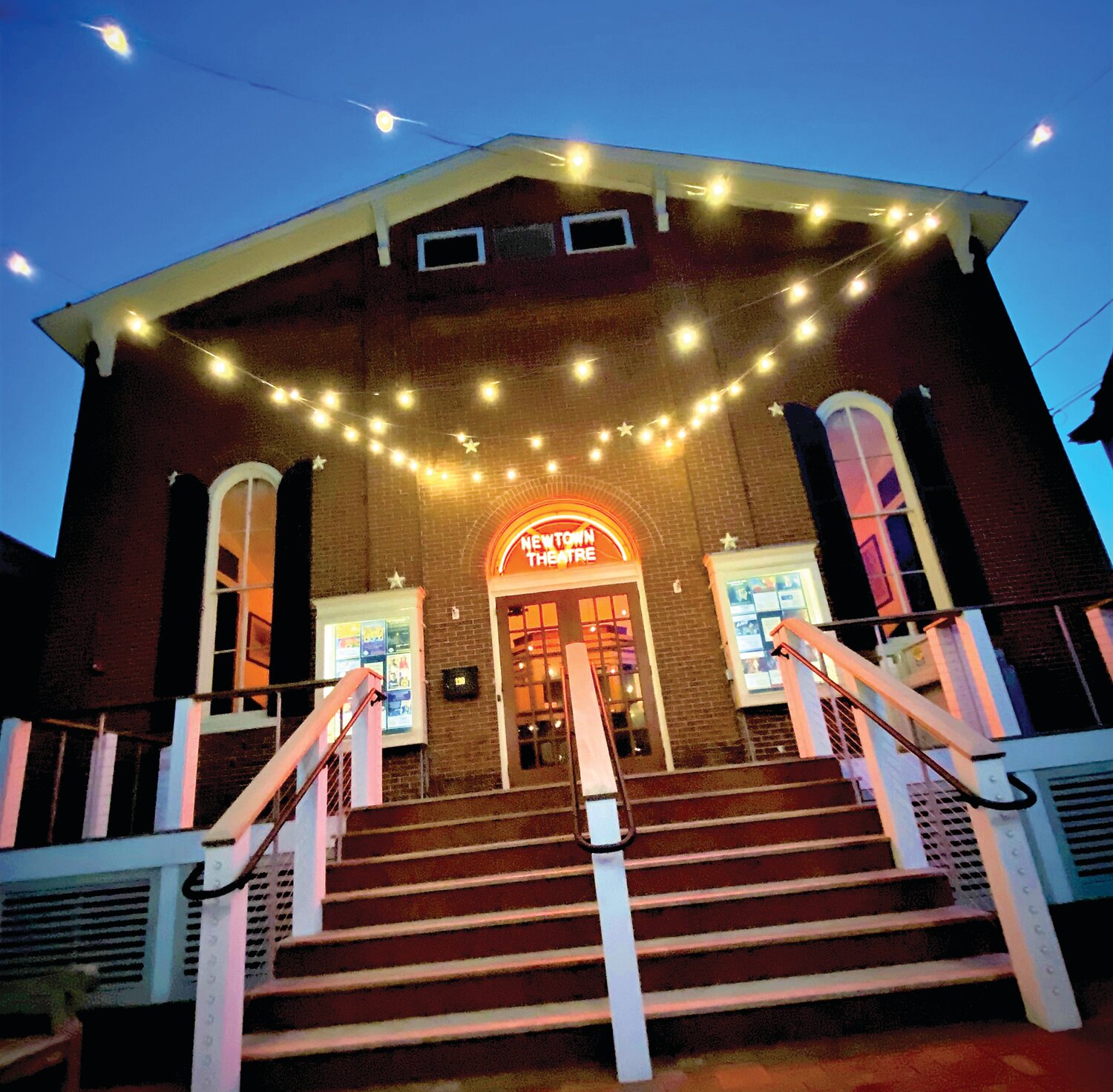 The historic Newtown Theatre is lit up at night.