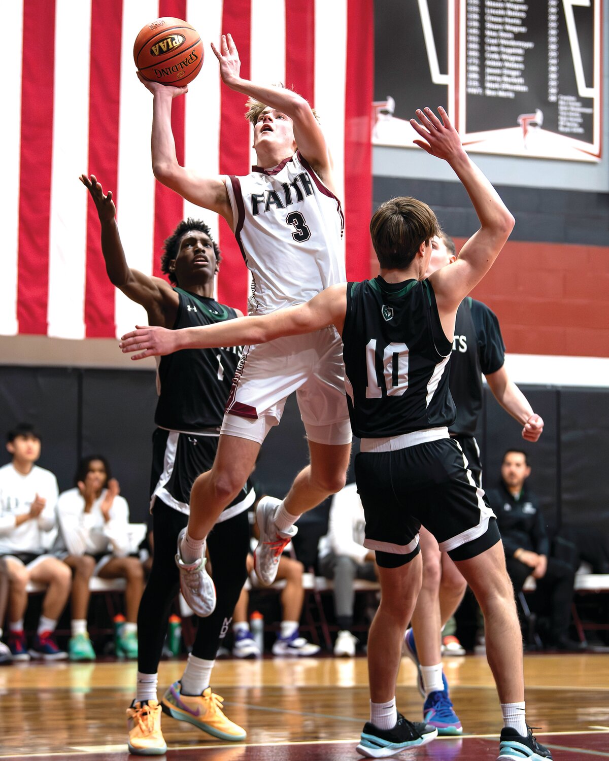 Faith Christian Academy’s Micaiah Hughes tries to get a shot off in the first half against Delco Christian’s double team.