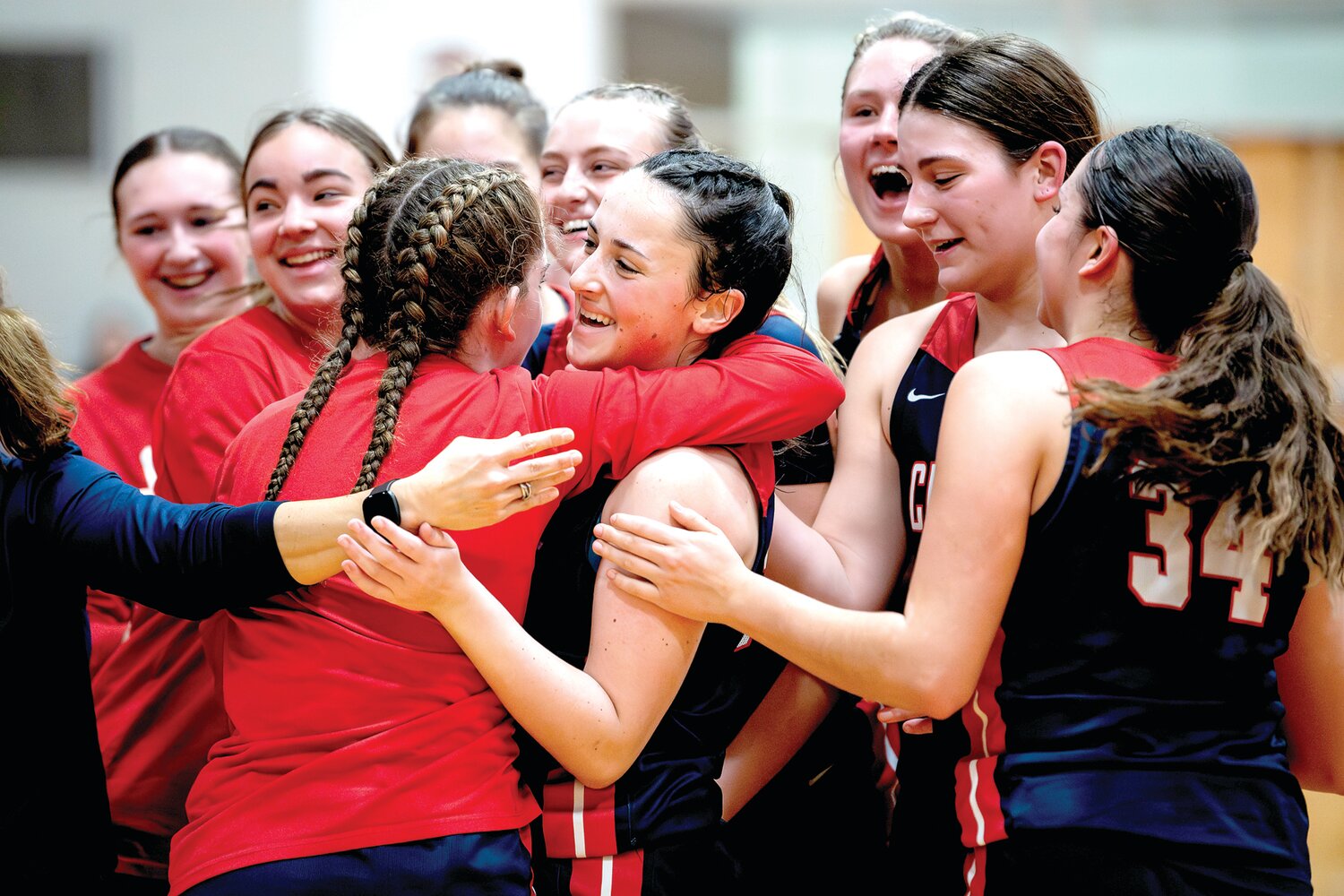 Central Bucks East’s Anna Barry gets mobbed by her teammates after sinking one of two foul shots in the fourth quarter for her 1,000th career point.