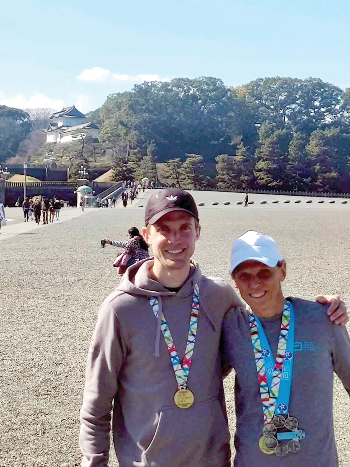 Nancy Smith and her son, Zach, celebrate with their medals upon finishing the Tokyo event.