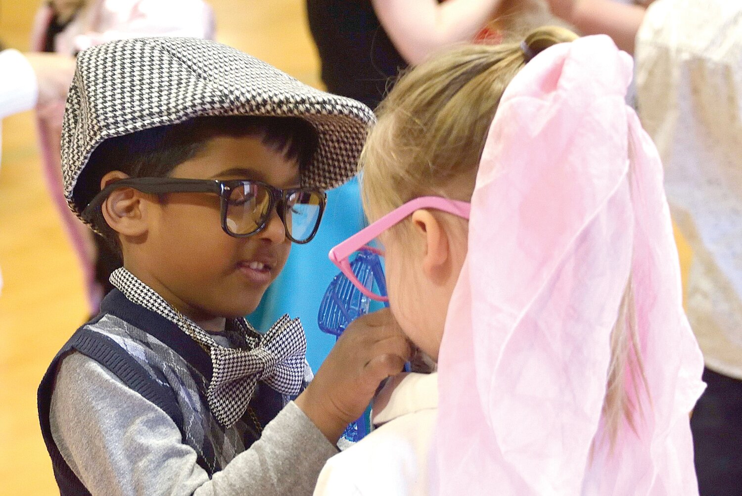 Sena Namburi, 5, helps Lyla Greenbacker, 4, with her glasses.