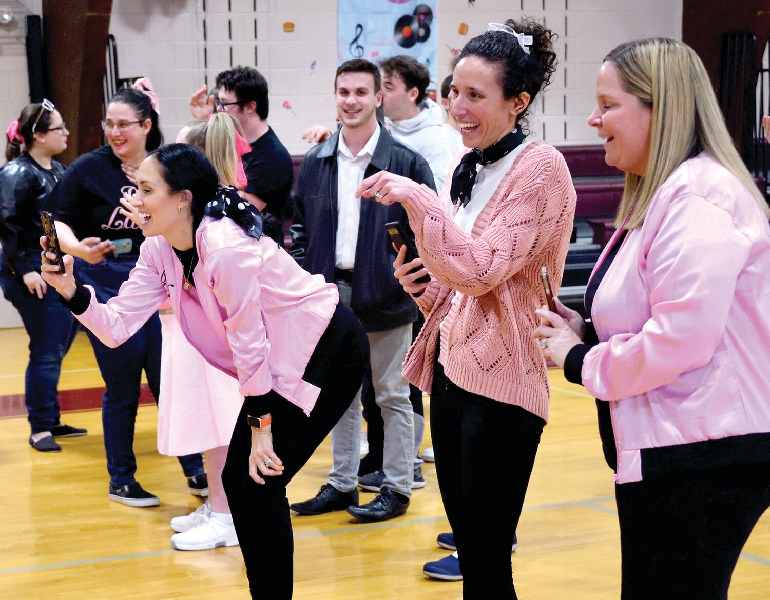 Parents shoot photos of their kids as they attend the St. Joseph/St. Robert dance on March 22.