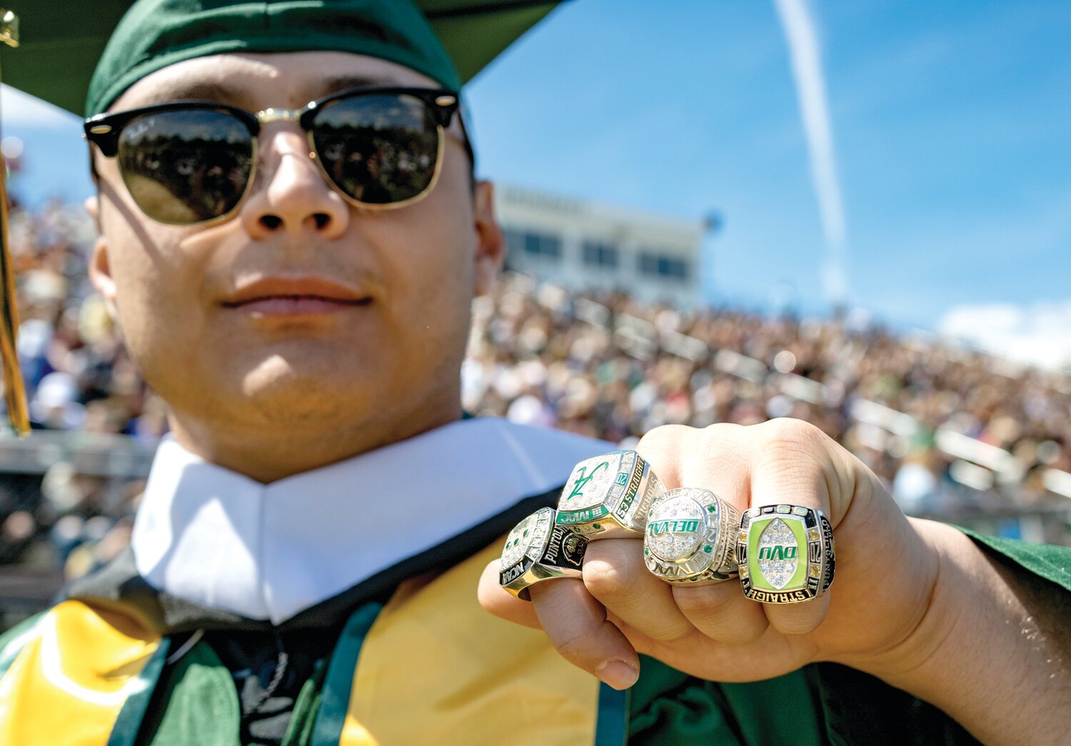 Delaware Valley University graduate Anthony Puntolillo flashes four rings, symbolizing accomplishments earned through his time as part of the university’s football team.