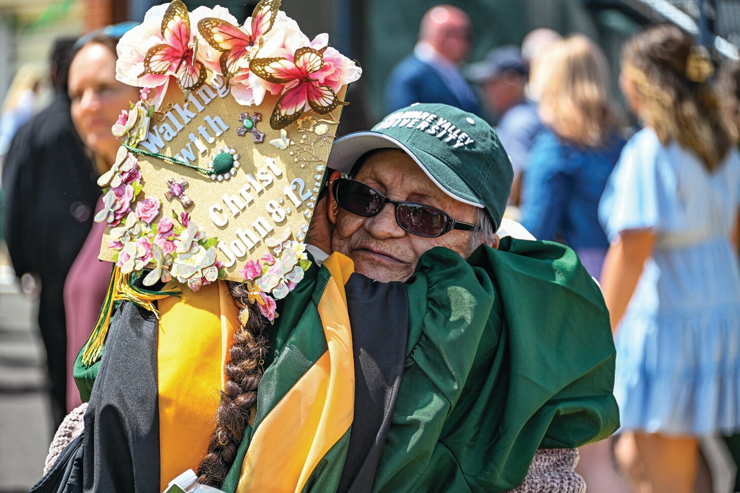 Donning a decorated cap, a member of the Class of 2024 gets a hug at Delaware Valley University’s commencement.