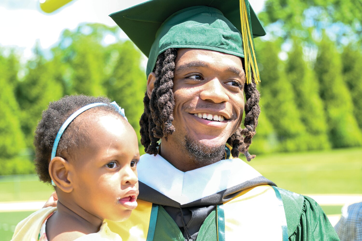 Delaware Valley University student Goddy Marc holds his niece as he celebrates his graduation Saturday morning.