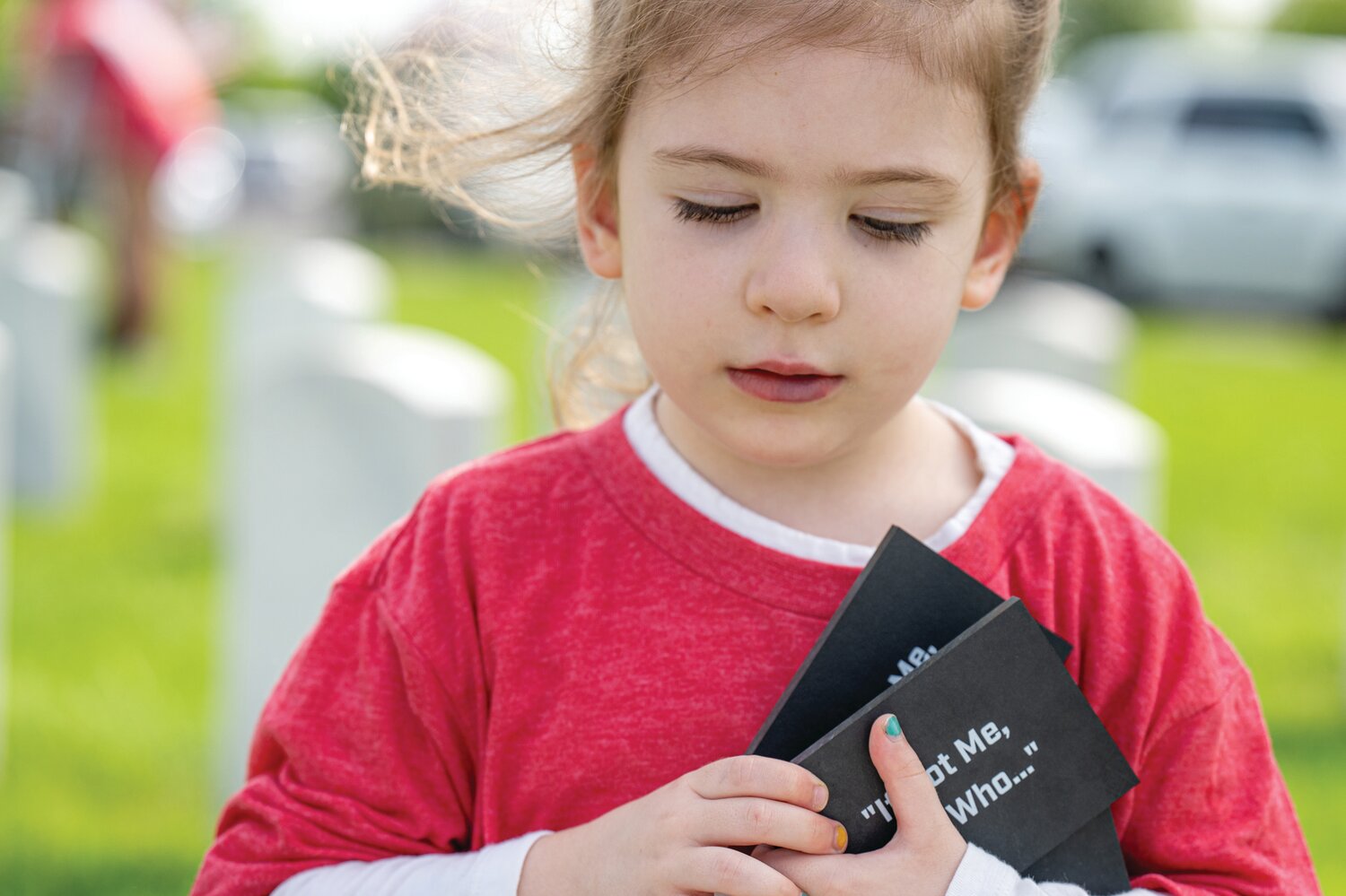 Sydney Heffron, 4, carries tokens to be placed on gravestones at Washington Crossing National Cemetery.