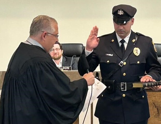 Magisterial District Judge Michael Petrucci, left, administers the oath of office to newly minted police sergeant Gerard Russi on May 21.