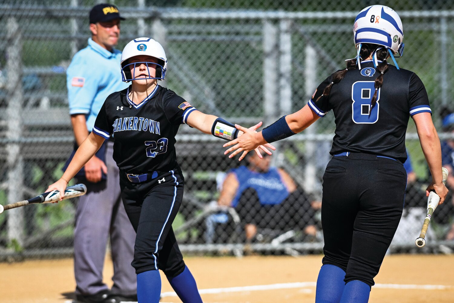 Quakertown’s Kayla Scheibenhofer gets a slap from Mary Wilkinson after scoring the Panthers first of three runs in the top of the fourth inning, tying the District One 6A final game at 3 apiece.