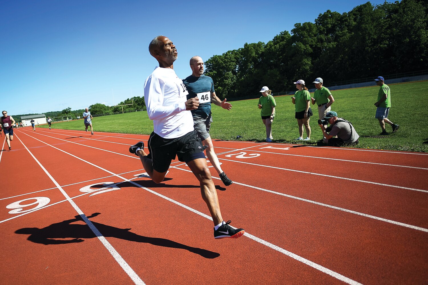 Gerry Bennett, left, crosses the line ahead of Brian Fitting to win the the first heat of the 100-meter dash.