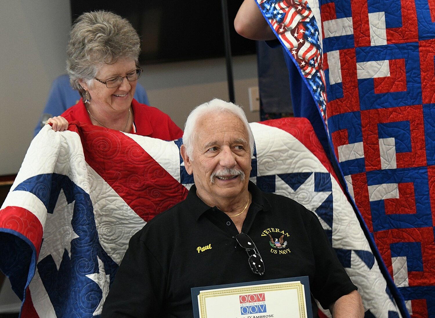 Paul D’Ambrose receives a quilt from Maureen Miller-Nemeth.