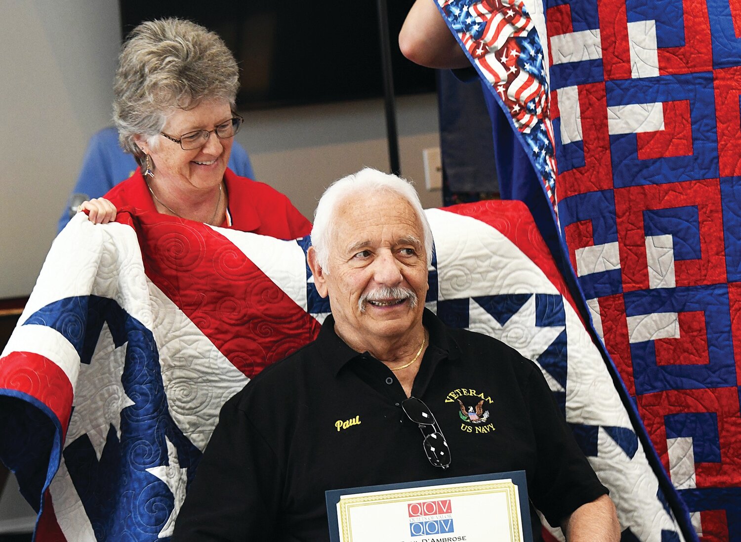 Paul D’Ambrose receives a quilt from Maureen Miller-Nemeth.