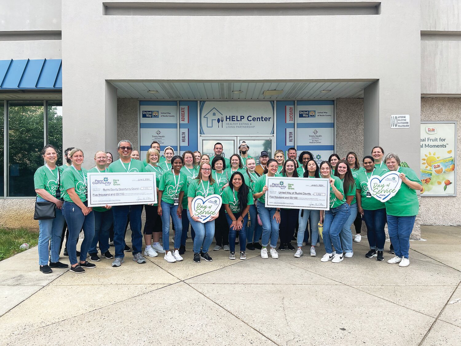 Penn Community Bank Employees hold ceremonial checks during their Day of Service.