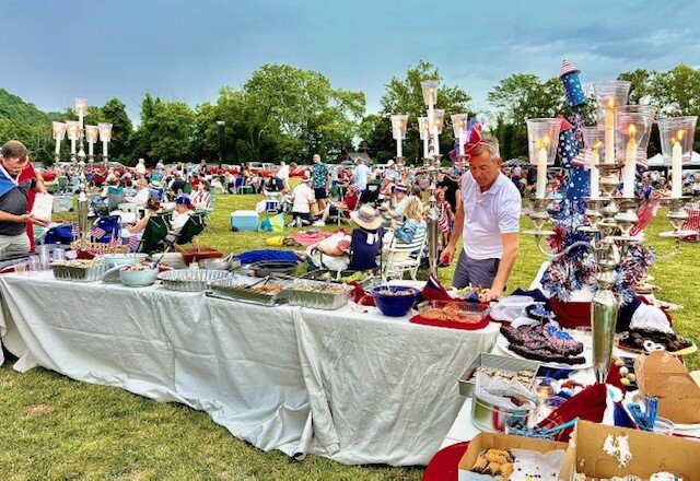 Multiple candelabras mark one Concert in the Park attendee’s dinner spread.