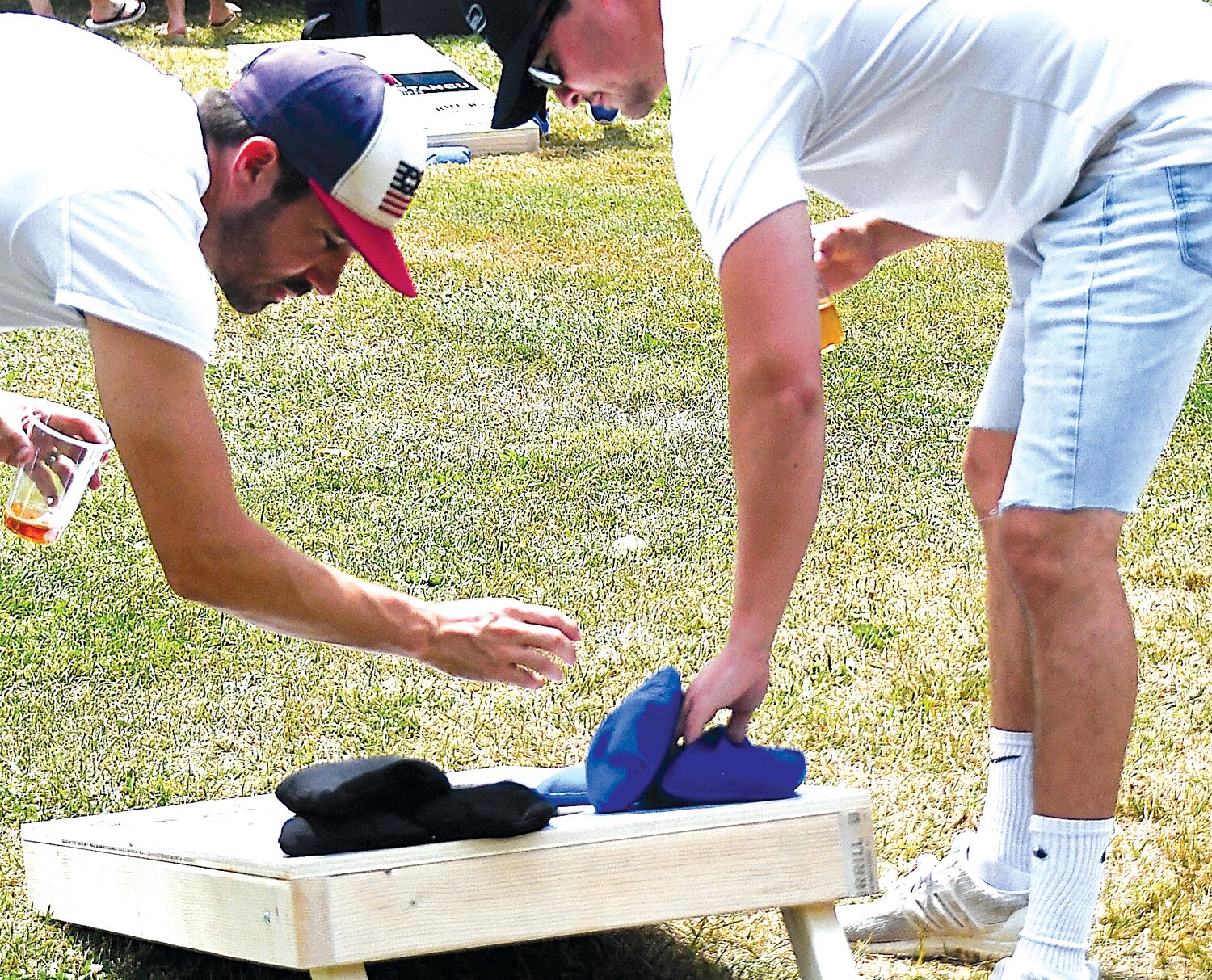 Derek Sipe, left, and Tim McCartney, Bucks County assistant district attorney, gather the bean bags after a toss.