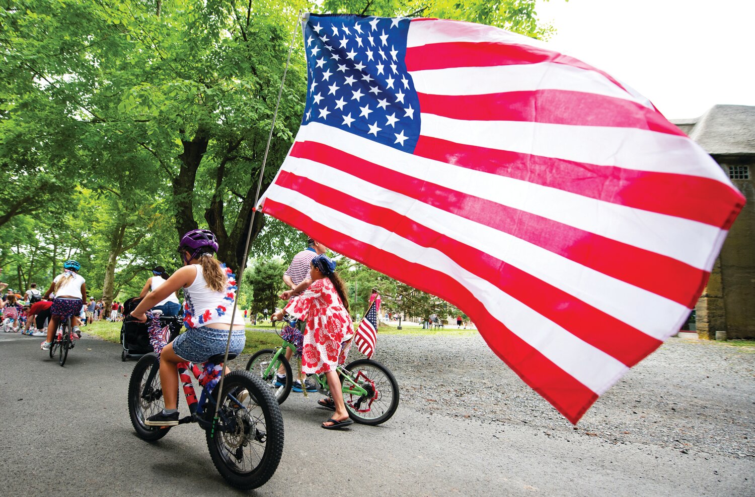 Children display their patriotism as they ride in a decorated bike parade at Fonthill Castle’s old-fashioned Fourth of July celebration.