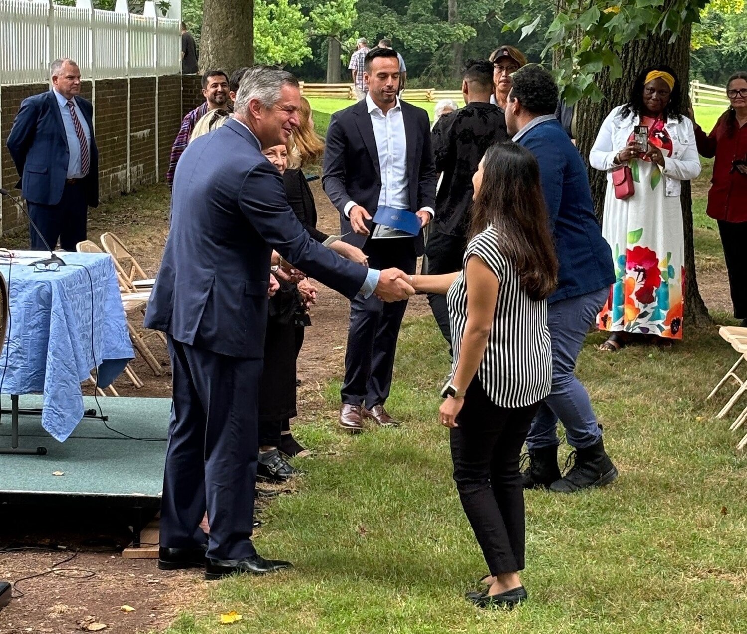 Bucks County Bar Association President Tyler Tomlinson shakes the hand of a new U.S. citizen.