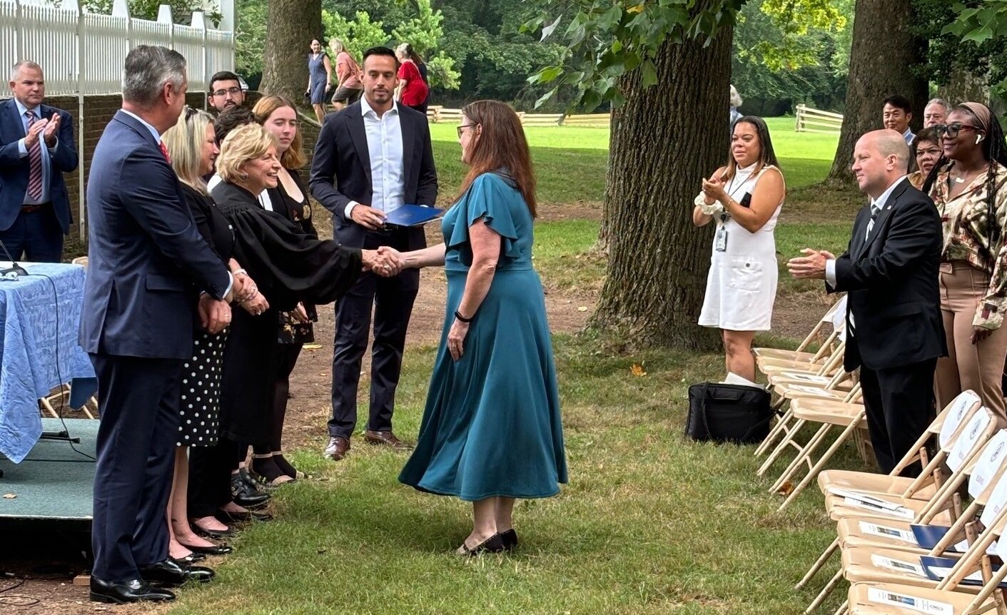 A new citizen accepts a congratulatory handshake on July 25.