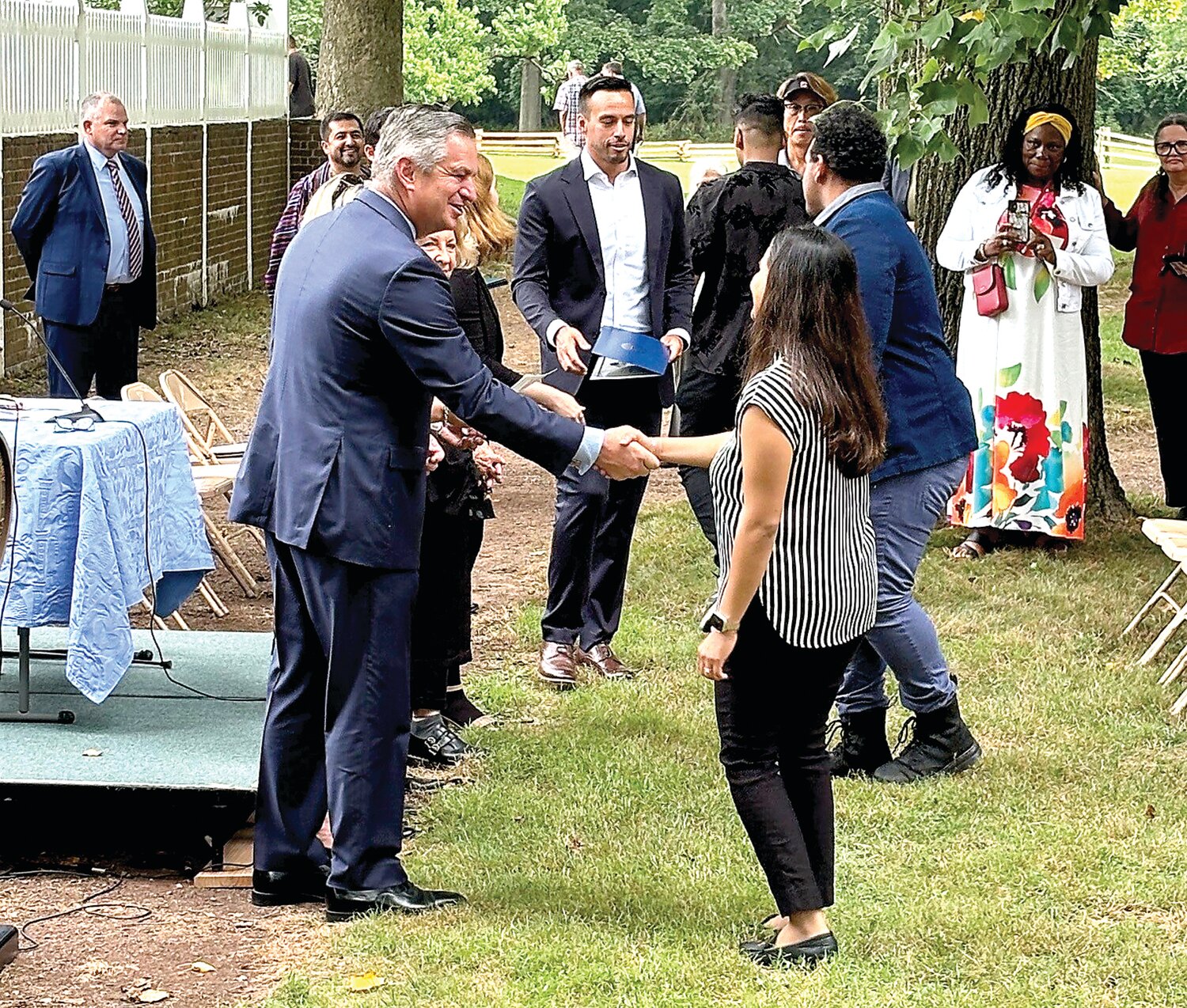 Bucks County Bar Association President Tyler Tomlinson shakes the hand of a new U.S. citizen.