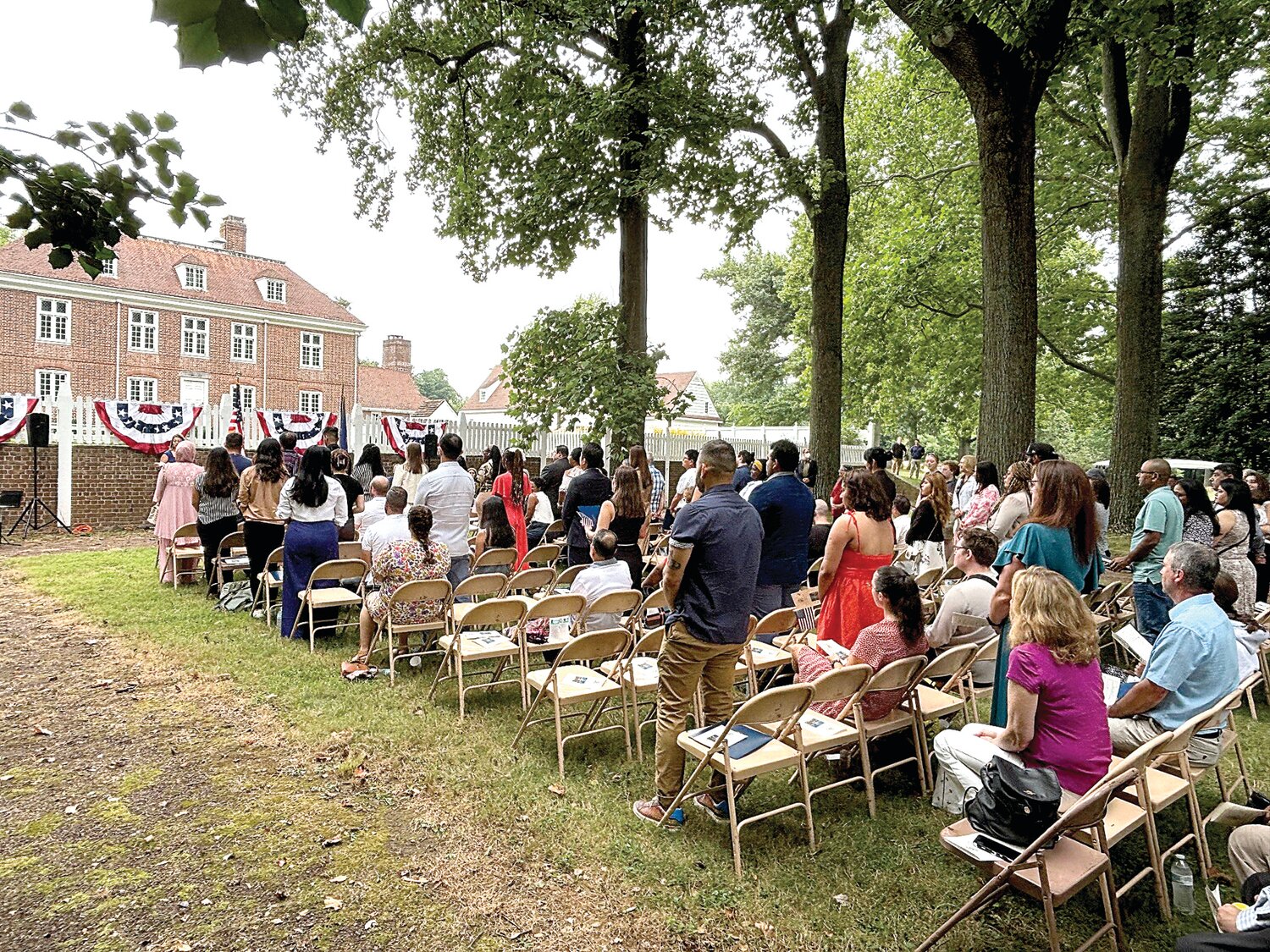 New U.S. citizens stand for the swearing-in.