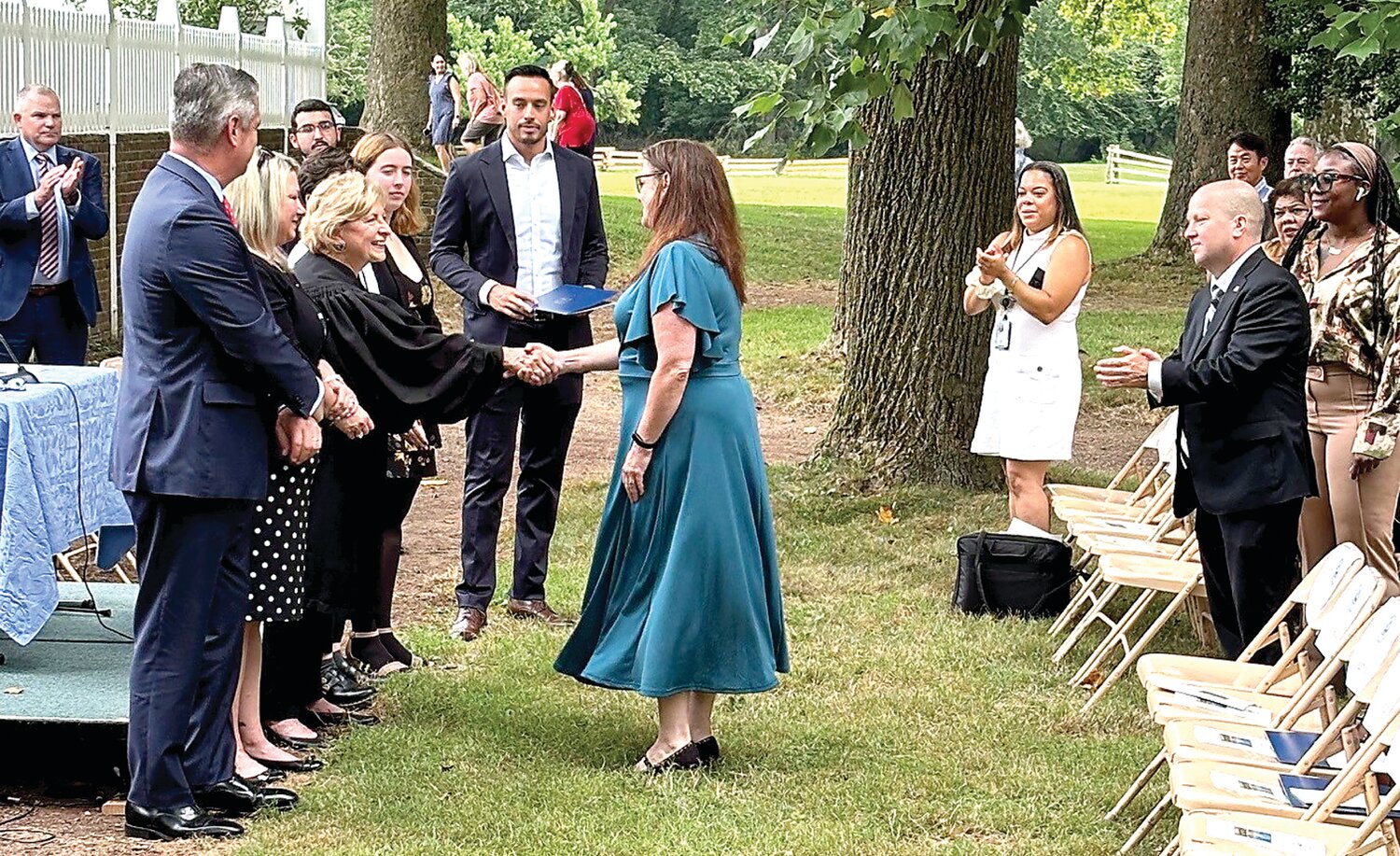 A new citizen accepts a congratulatory handshake on July 25.