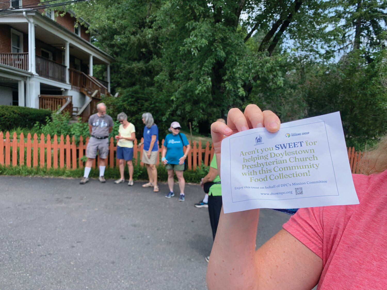 Doylestown Presbyterian Church (DPC) member Amy Edenson holds up one of the thank-you gifts left on the doorsteps of residents who contributed to the church’s first Community Food Collection on July 28.