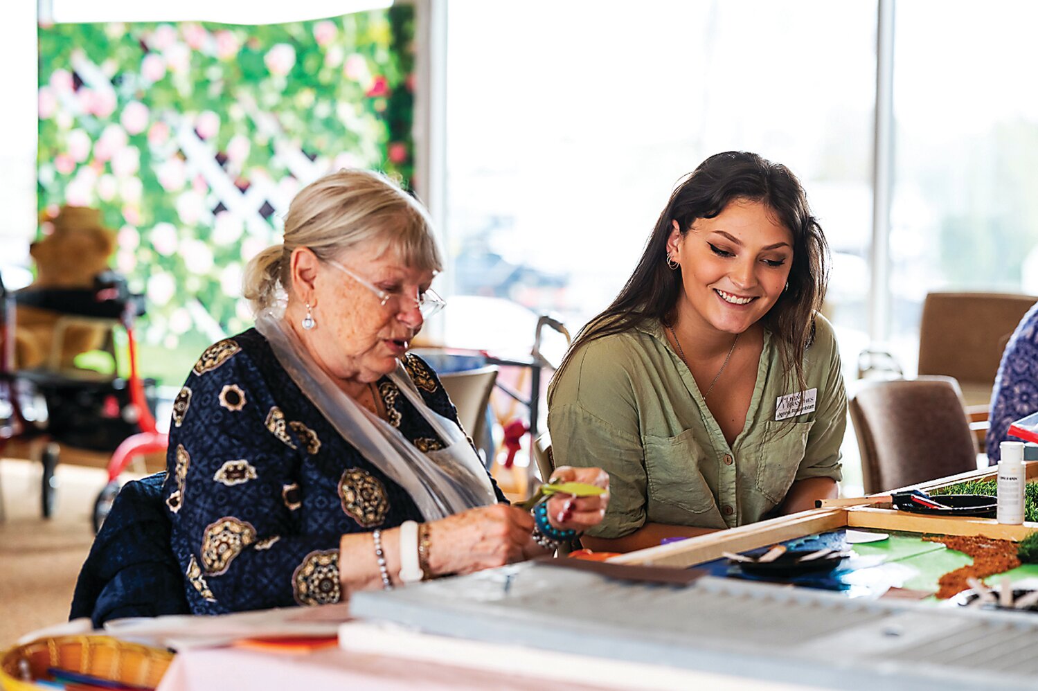 Temple University art therapy intern Jenna Rosenblatt works with personal care residents at The Willows of Living Branches to create a 7-foot farmland mural for residents living with dementia at Souderton Mennonite Homes.