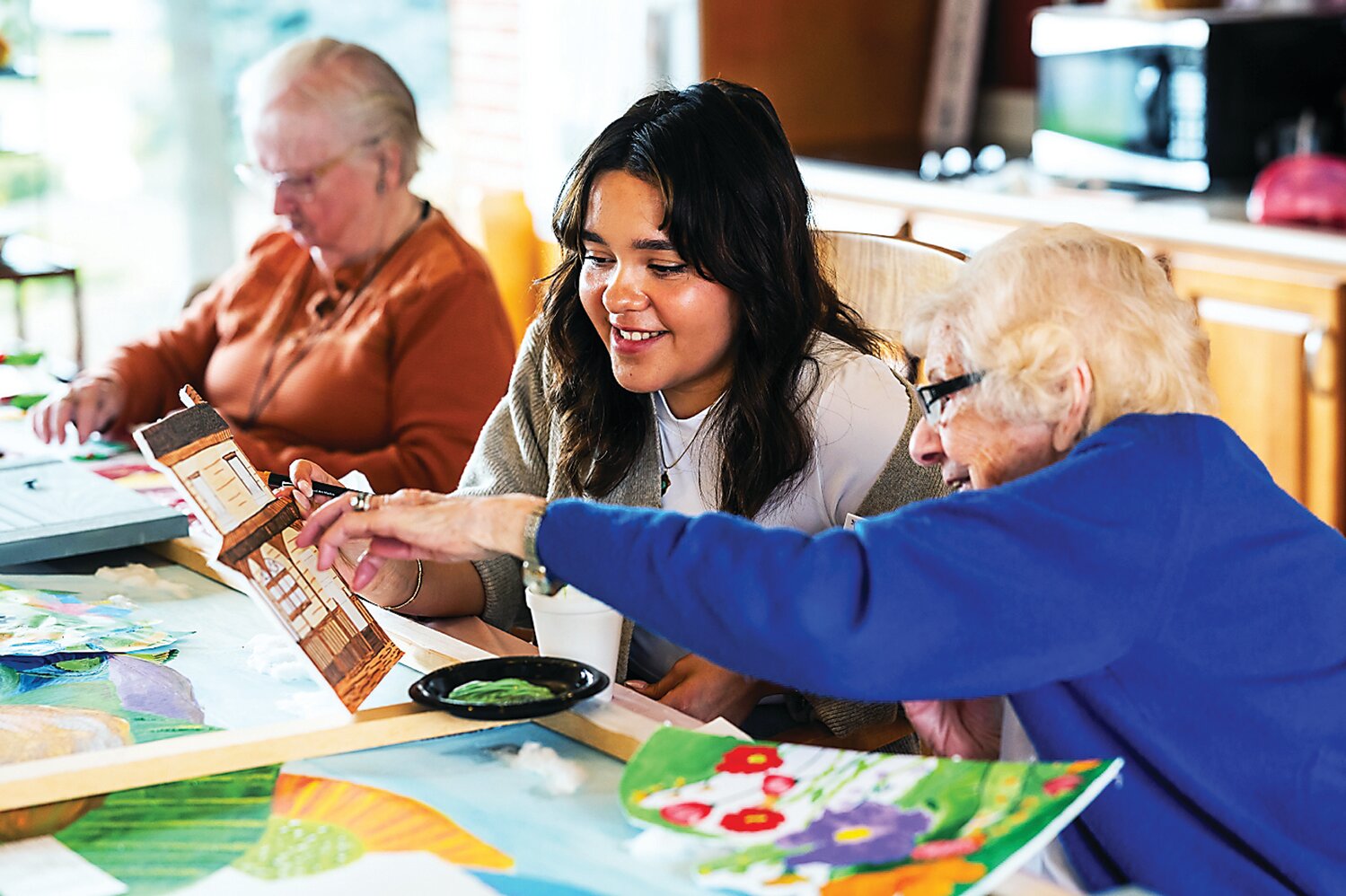 Temple University art therapy interns Julie Vasquez works with Personal Care residents at The Willows of Living Branches to create a 7-foot farmland mural for residents living with dementia at Souderton Mennonite Homes.