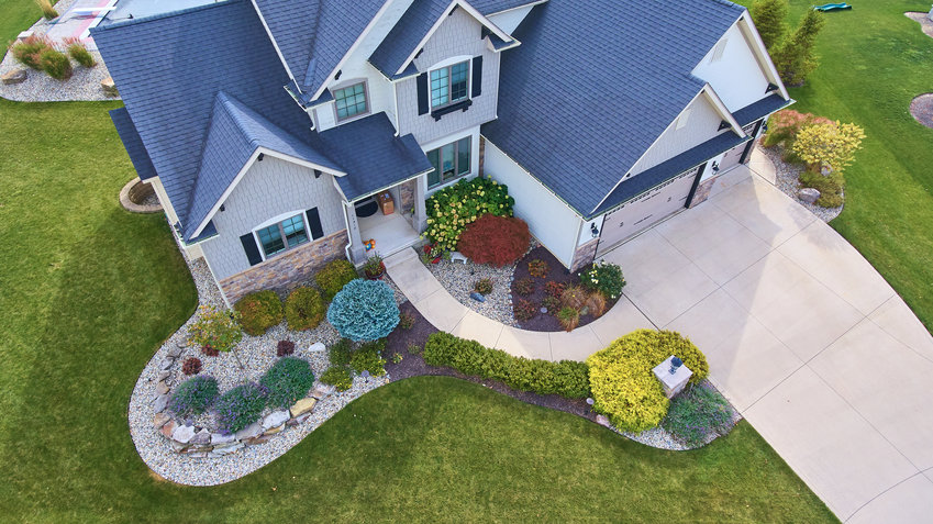 Image of View of outside of traditional american house with beautiful summer landscaping