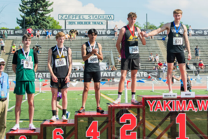 Mossyrock’s Matt Cooper fist bumps other athletes after taking first in the 800 meter run at Zaepfel Stadium in Yakima on Saturday.