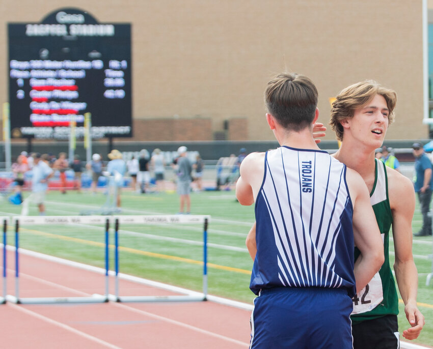 Pe Ell’s second place 100 and 300 meter hurdler Carter Phelps hugs his opponent as the scoreboard displays their final times in the State track and field meet in Yakima on Saturday, May 27.