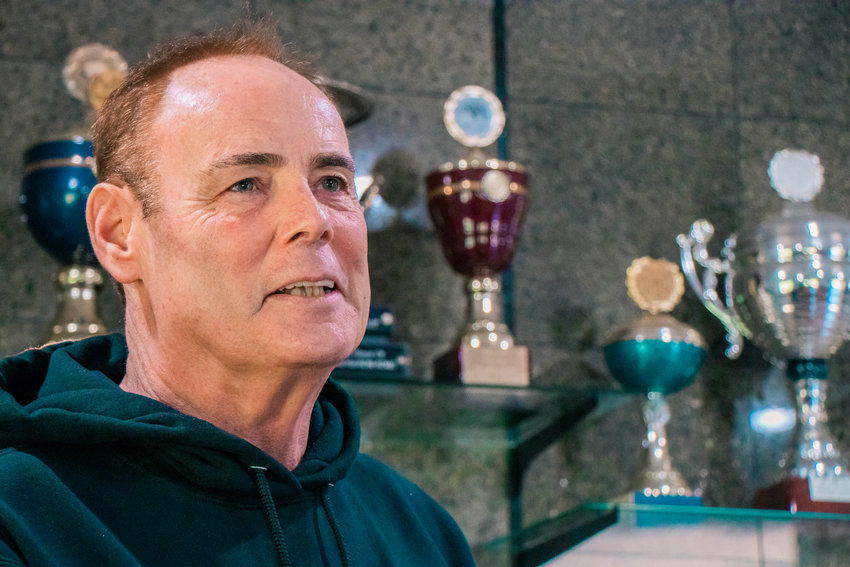 Wayne Curry talks about competitions while standing in front of an array of trophies at Kraftwerk K9 German Shepherds in Rochester in 2023.