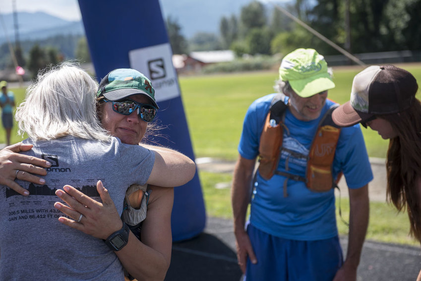 Angela Wilder of McCleary (left with glasses) gets a hug after crossing the Bigfoot 200 finish line.