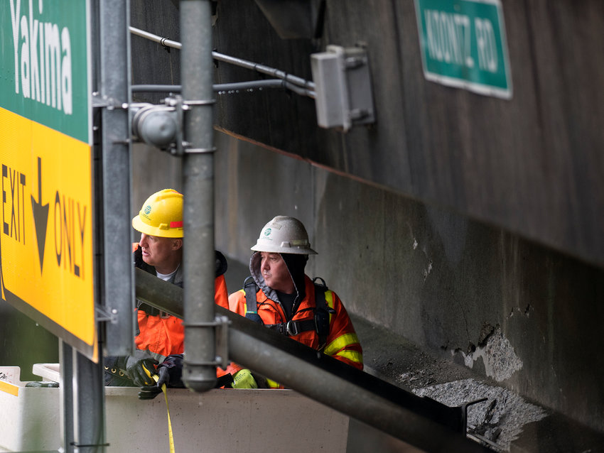 In this Dec. 8, 2015 file photo, workers from the Washington Department of Transportation inspect the Koontz Road overpass on Interstate 5 after it was struck by an oversized truck near Napavine.
