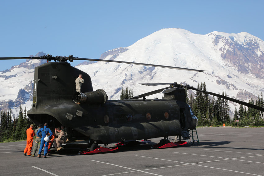 FILE PHOTO &mdash; In this photo provided by the National Parks Service, search and rescue workers stand next to a Chinook helicopter at Mount Rainier as they are briefed prior to resuming the search for a 64-year-old man who went missing after he was last seen hiking the Wonderland Trail at Mount Rainier.