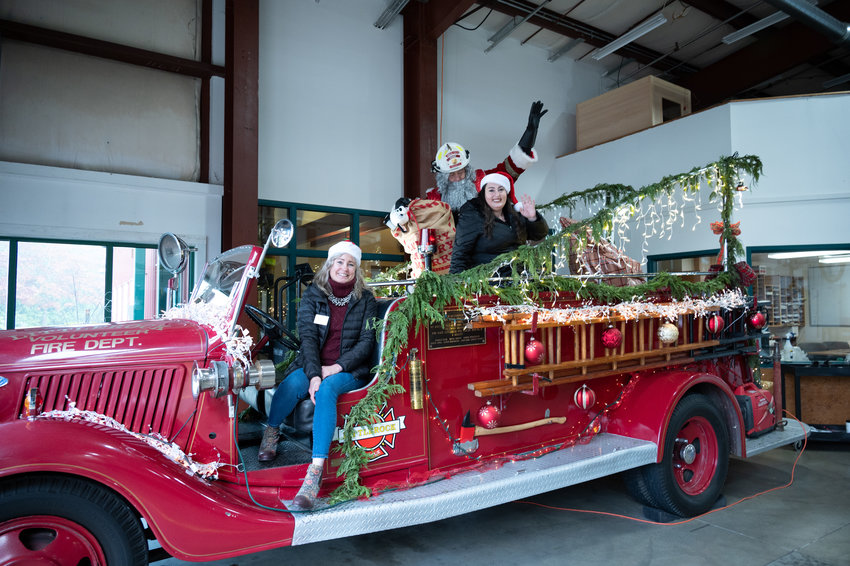 FILE PHOTO &mdash;&nbsp;Santa, also known as Tom Fitzgerald, a battalion chief for West Thurston Regional Fire Authority, poses atop the original 1936 Ford fire engine that was the first ever used by the fire district, during a ceremony at the fire district headquarters in Littlerock on Friday, Dec. 17, 2021. Leaders of the Thurston County Chamber delivered bags of toys and a $1,000 check to the Littlerock and Rochester fire stations. Firefighters there will use the money to buy toys and other Christmas gifts for needy rural families as part of the AWB Holiday Kids&rsquo; Tree Project. Employers and donors across the state have donated more than $500,000 to this project since it began in 1989. This year, 78 member businesses of the Association of Washington Business and other individuals have given more than $37,000 to the project, enough to give $1,000 and a bag of toys to 24 rural fire districts in 14 counties across Washington. Fire officials use the money and toys to deliver Christmas gifts and cheer to needy kids and families in their communities. (Photo: Brian Mittge/AWB)