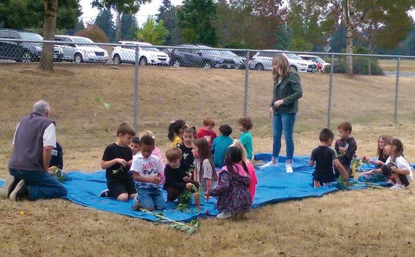 Mark Watrin teaches students from Glenwood Heights Primary School about gardening.