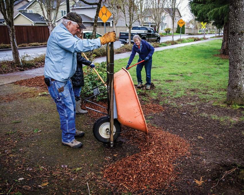 Volunteers with the Lions Club spread new bark dust at Florence Robison Park North on Saturday, April 22.