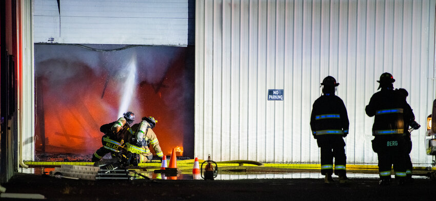Firefighters battle flames as debris collapse to the ground inside a structure in the 100 Block of Alder Avenue Northwest in Napavine on Saturday, June 3.