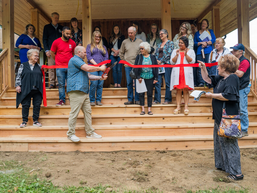 Members of the South Thurston Economic Development Initiative Council watch Mayor of Tenino Wayne Fournier cut the ribbon in front of the Quarry House in Tenino on June 16.  The historic building underwent significant renovations, in part funded by a $350,000 Community Development Block Grant that Thurston County provided in 2019. The Quarry House was originally the quarry office and headquarters of Tenino Sandstone Company and has been in the city for over 100 years. It is now used as a community center in Tenino City Park.