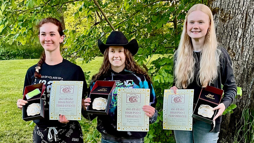 From left, gaming high point earner Josey Majors, versatility high point earner Kylee Smith and performance high point earner Maizy Samuelson smile for a photo with gold belt buckles and certificates at Lintott-Alexander Park in May.