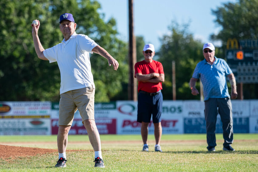 Ken Anderson winds up to throw the ceremonial first pitch as Ray Butler (in red) and Bill Lohr (in blue) watch before I-5 Toyota/Mountain Dew's game against Gonzaga Prep in the American Legion AAA state tournament, July 22 at Wheeler Field. Anderson, Butler, and Lohr were members of the 1958 Centralia Legion team that won a state title and is set to be inducted into the Washington American Legion Hall of Fame this fall.