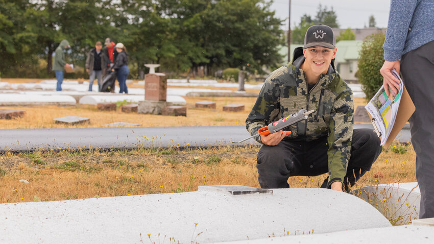 Jacob Price, 17, of Adna, smiles while completing an Eagle Scout project at Greenwood Memorial Cemetery with the help of family, friends and former scouts on Saturday, Aug. 5, in Centralia. The project aimed to clean the cemetery grounds and place flag holders at the graves of veterans.