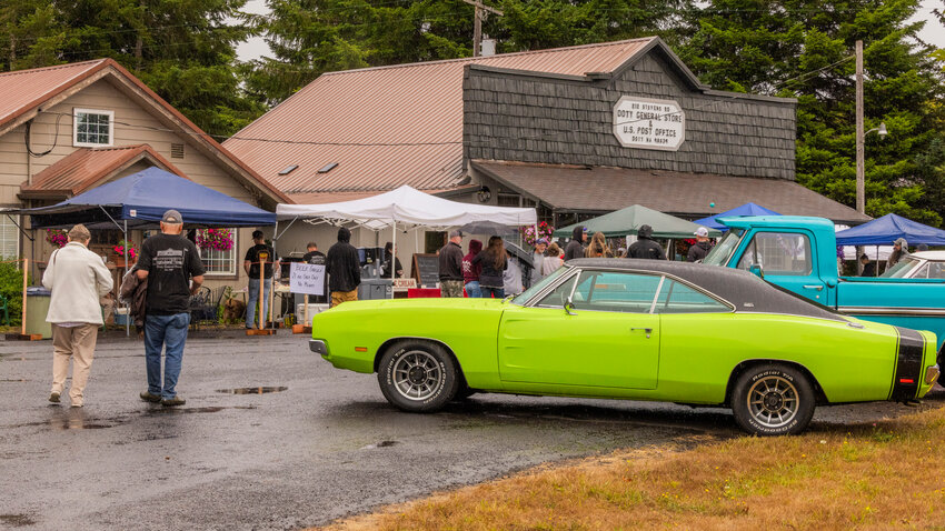 Attendees mingle around vendors and vintage vehicles on display outside the Doty General Store during a car show event on Saturday, Aug. 5. The show was hosted by the Hub City Cruisers. Car enthusiasts were invited to check out classic and custom cars and enjoy burgers and ice cream at the event.
