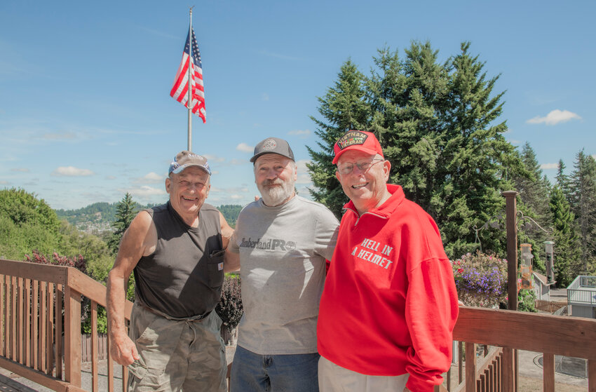 From left, John Sauter, Wayne Gray and Terry Wilson smile for a photo in front of a flag pole constructed in Wilson&rsquo;s yard off Polaris Plaza in Chehalis.