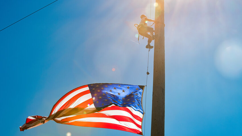 A flag blows in the wind as Maxwell Lloyd competes in the speed climb event inside the Morton Loggers&rsquo; Jubilee Arena in August of 2022.