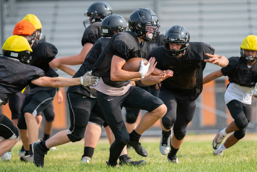 Hunter Howell runs through an attempted tackle at Rainier's practice on Wednesday, Aug. 23.