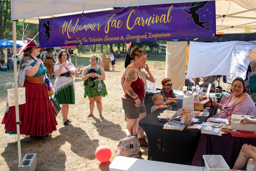 Attendees purchase tokens to use for the games at the Midsummer Fae Carnival at Schaefer County Park in Centralia on Saturday, Aug. 26.