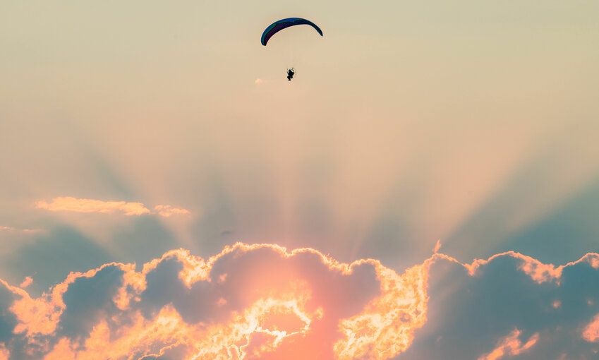 A powered paraglider flies above Chehalis at sunset on Friday. After an extended heat wave with plenty of sun, the region is expected to see more cloudy skies with the possibility of rain this week as daily high temperatures return to the 60s and 70s.